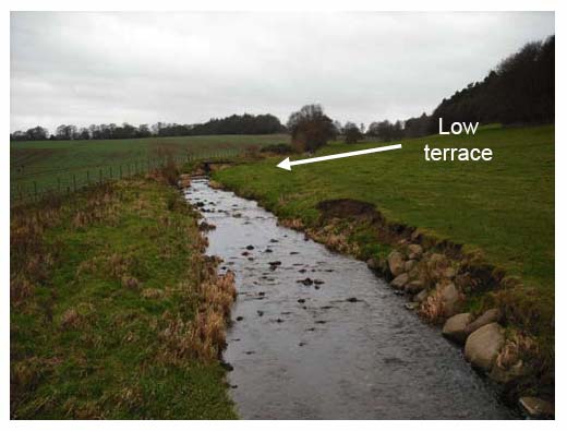 Photograph 3.6: Upstream view of Niddry Burn illustrating local erosion and protection