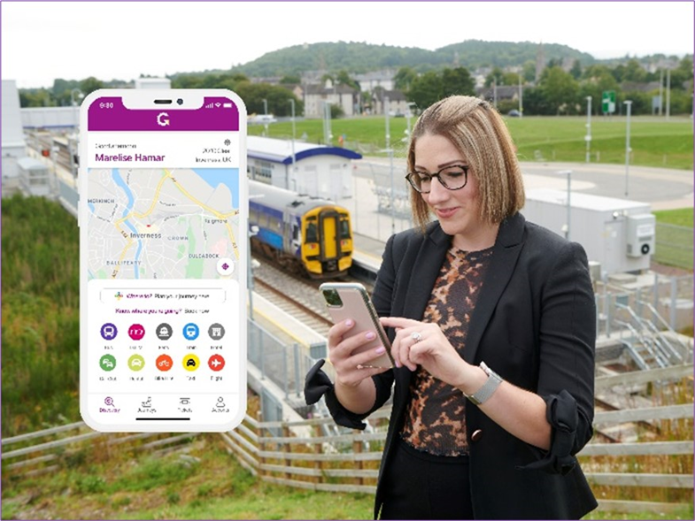 A woman looks at her phone. A ScotRail train is in the background. There is an inset of a phone with the Go-Hi App showing.
