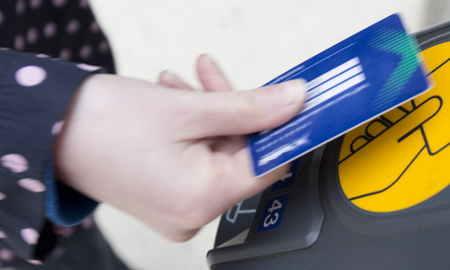 A passenger uses a smartcard to get through a ticket barrier