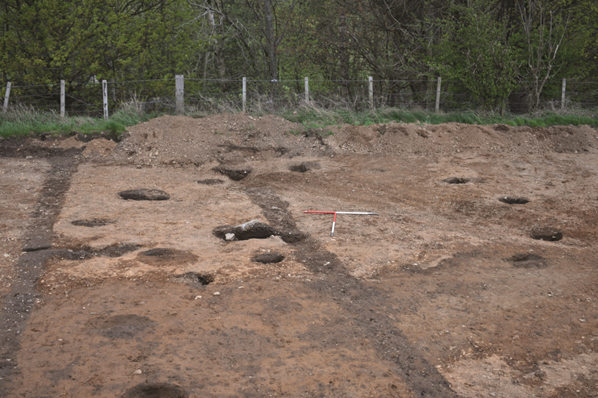 A ring of postholes marks the location of upright posts for a roundhouse