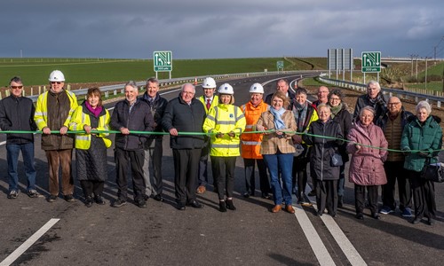 Transport Minister Jenny Gilruth, site staff and community members cutting the ribbon to open the new A77 Maybole Bypass