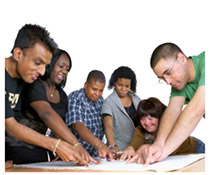 A team of 6 people all crowded around the same plan on a table, pointing together at the centre.