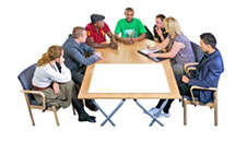 7 people meeting round a table.