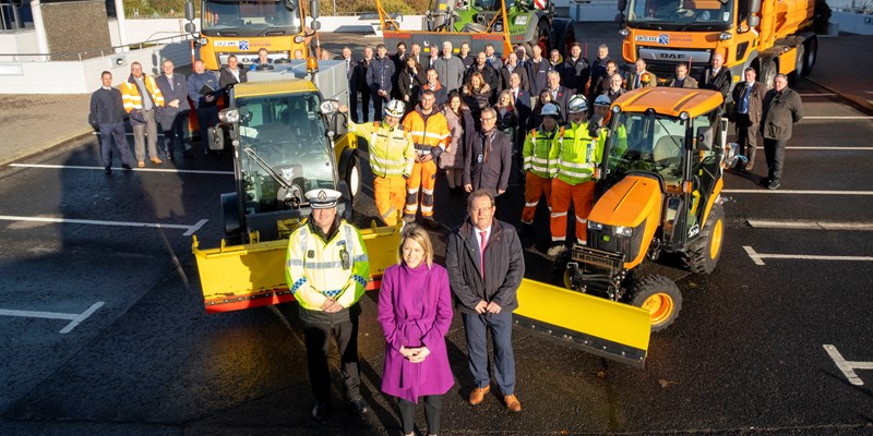 Transport Minister Jenny Gilruth MSP, with a group of people forming part of our winter team - all standing in front of vehicles from our Winter Fleet