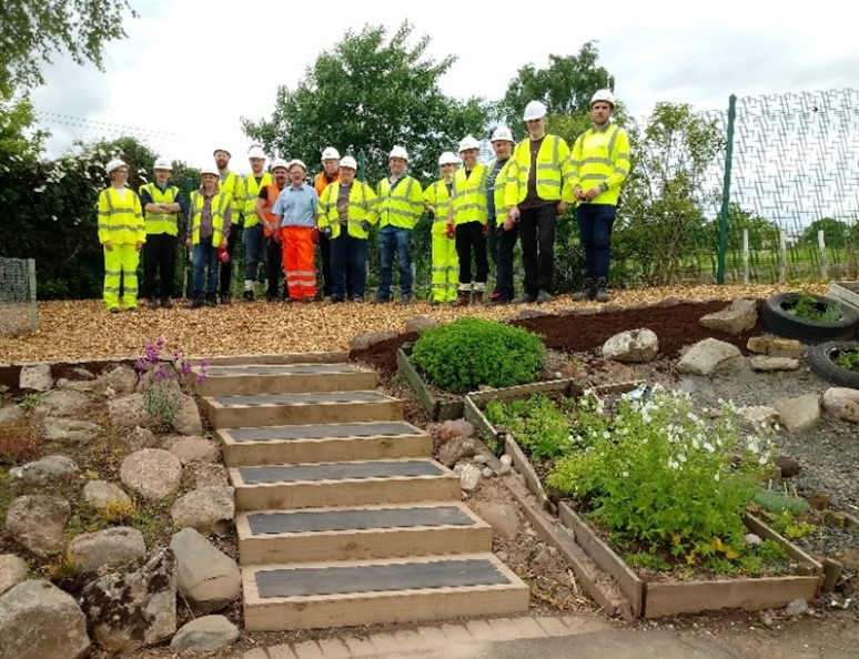 The volunteering team in front of a freshly landscaped garden