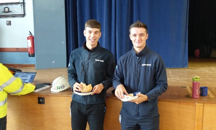 Two apprentices eating bacon rolls at a Bridges to Schools event at Blairgowrie High School