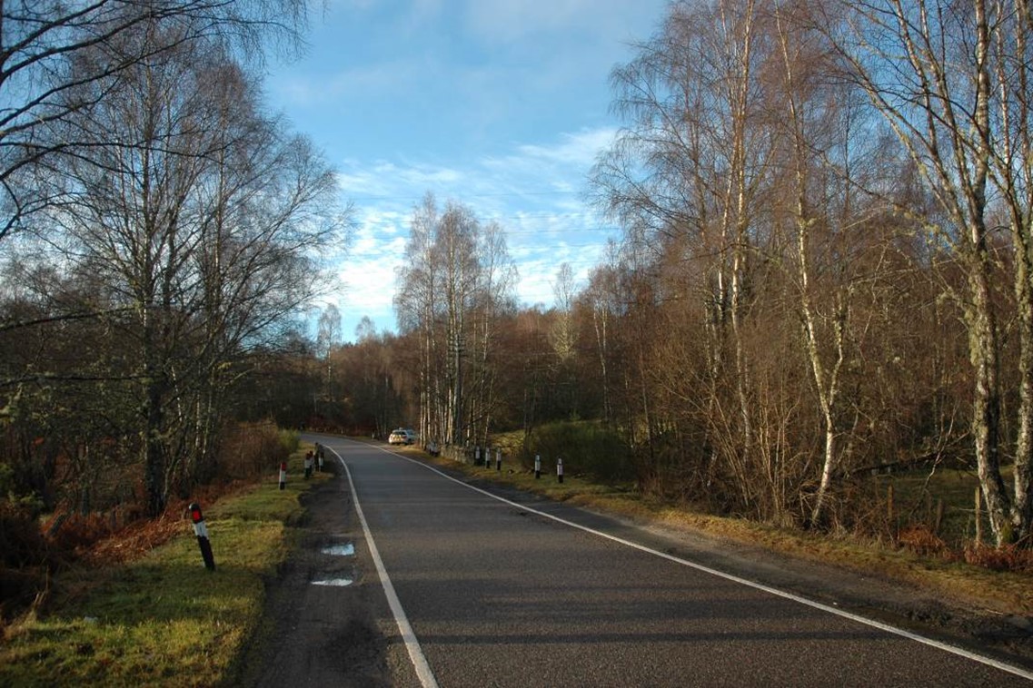 Single track road passing through rural woodland countryside
