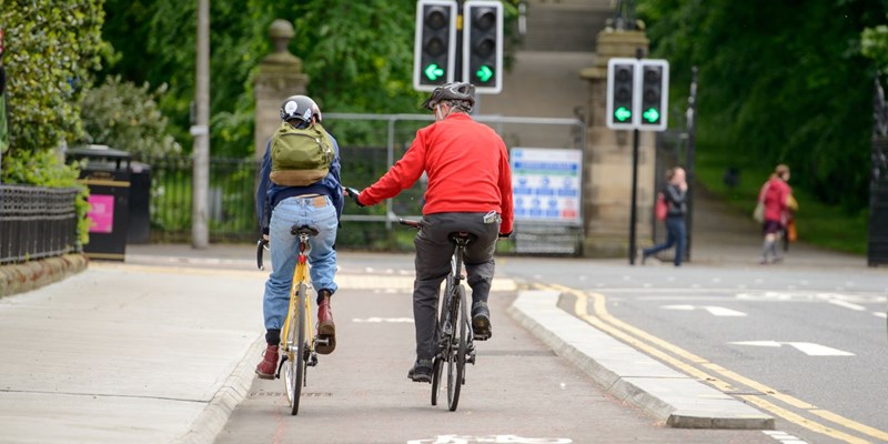 Cyclists on a cycle path approaching Queens Park in Glasgow