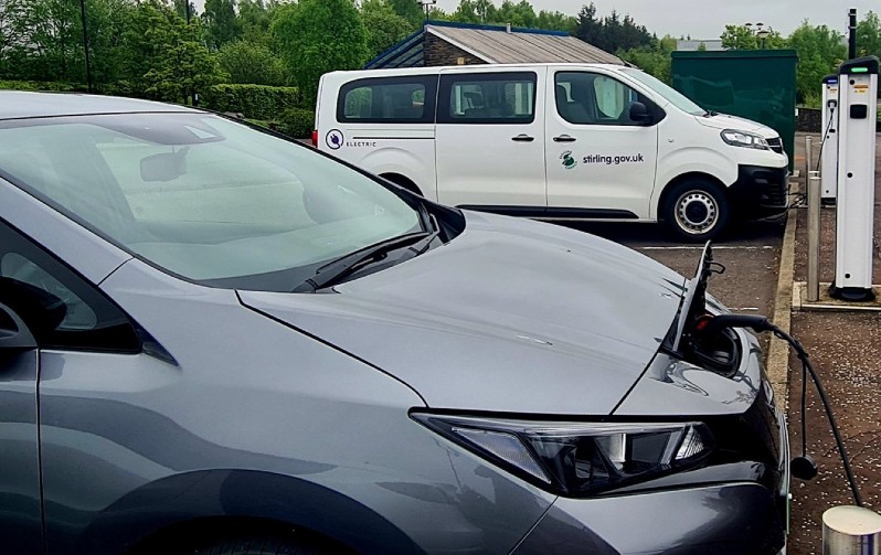 A picture containing and electric car and an electric van using an electric vehicle charge point.
