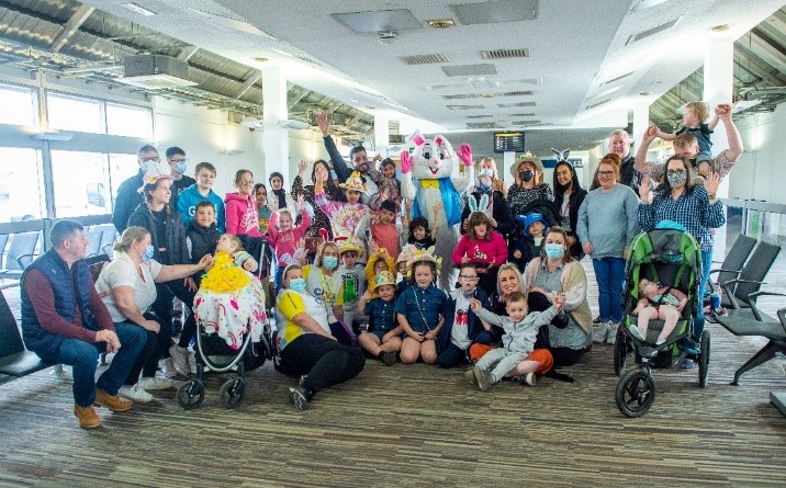 Group photo of families in airport before boarding flights provided by Loganair in aid of CHAS