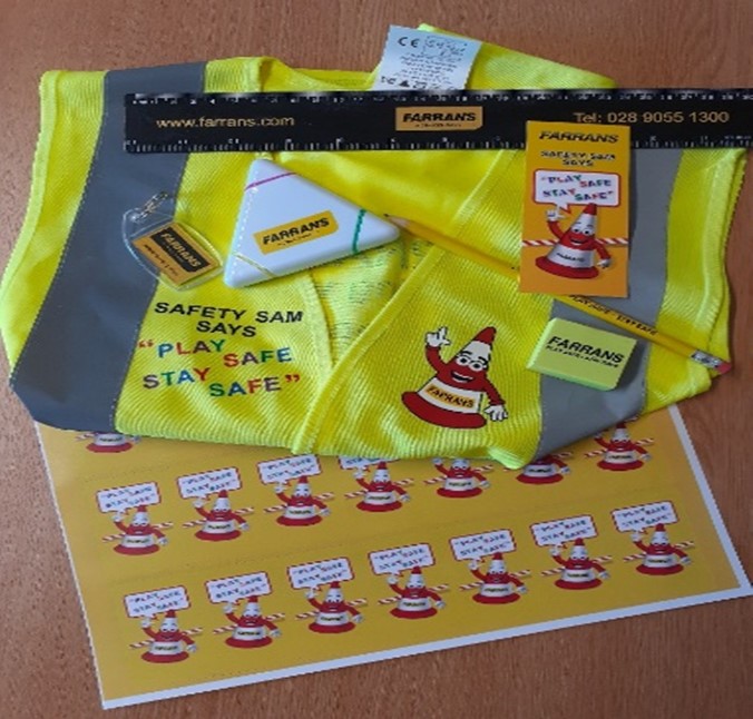 A photograph of high vis vest, highlighter pens, ruler, pencil, rubber and stickers with logo of safety cone with Farrans branding