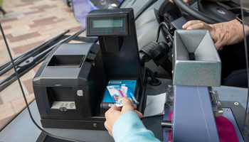 A person scanning a Young Scot card on a bus for free travel.