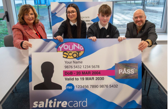 Minister for Transport Fiona Hyslop and Minister for Zero Carbon Buildings and Active Travel and Tenants’ Rights Patrick Harvie holding up a cardboard Young Scot card along with Wester Hailes High School students.