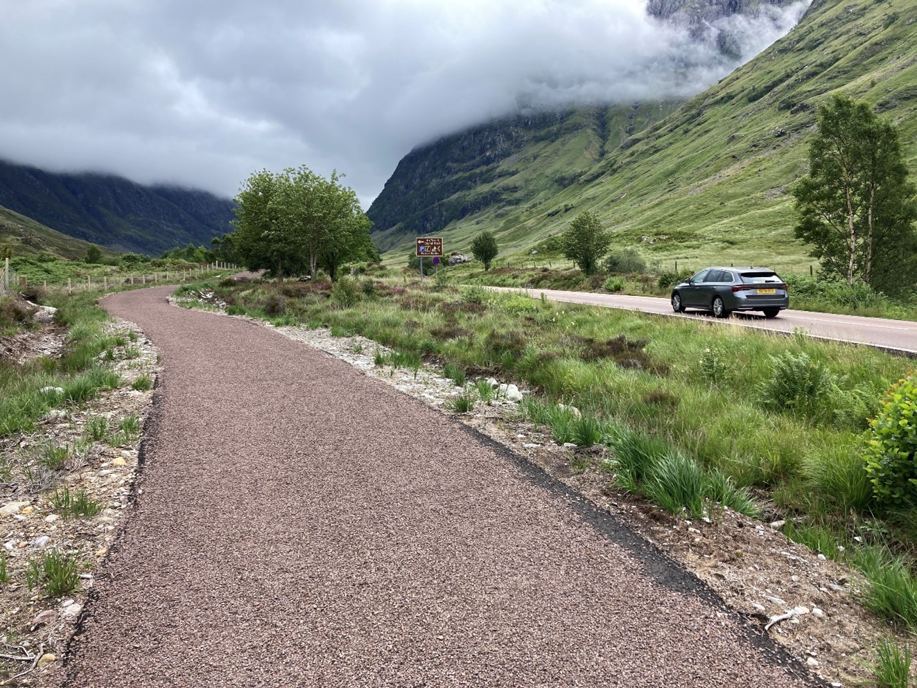 A newly constructed pedestrian path running alongside a rural road.
