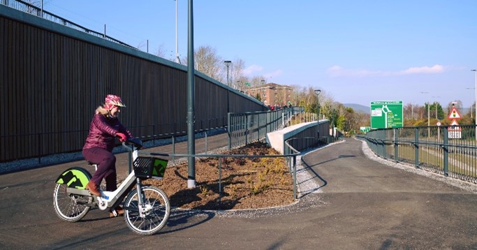 A photograph showing a cyclist on an electric bike