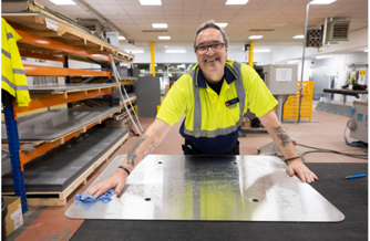 Person wiping a piece of metal in a workshop