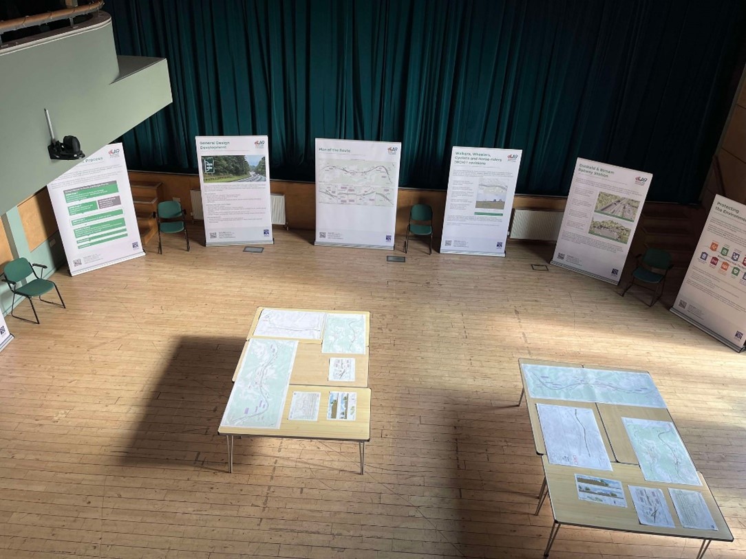 View looking down on the community engagement event space showing how the information banners were laid out and the tables with scheme drawing, maps and other details were presented.
